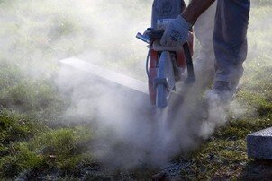 Coupe de bordures Scie à matériaux entrain de couper une bordure en granit