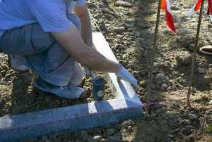 Poseur de bordure en granit sur chantier